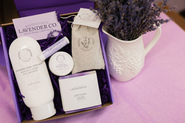 One of our subscription boxes, containing hydrating cream, lip balm, soap, and a surprise item in a small, burlap bag.